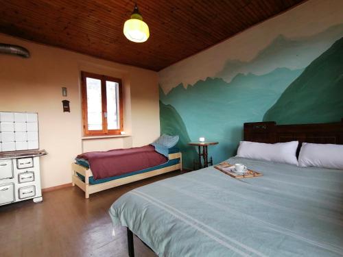 ein Schlafzimmer mit einem Bett und einer Bank darin in der Unterkunft Casa d'arte in the mountains on Lake Orta - 16 per in Quarna Sotto