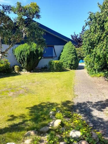 a house with a grassy yard next to a driveway at Flat, heart of Billund, 600m to Lego House, close to Legoland, Lalandia, Airport, in Billund
