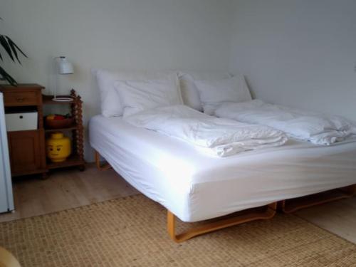 Cette chambre comprend un lit avec des draps blancs. dans l'établissement Flat, heart of Billund, 600m to Lego House, close to Legoland, Lalandia, Airport,, à Billund