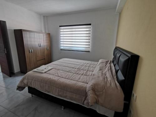 a bedroom with a large bed and a window at El Depa de Saulo in Tarija