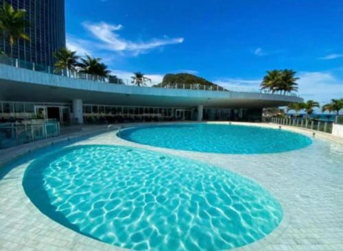 a large swimming pool in front of a building at Hotel Nacional Apart Lux in Rio de Janeiro