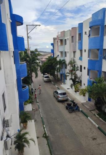 una calle de la ciudad con coches aparcados en el lateral de un edificio en Habitaciónes El Mirador, en Cartagena de Indias