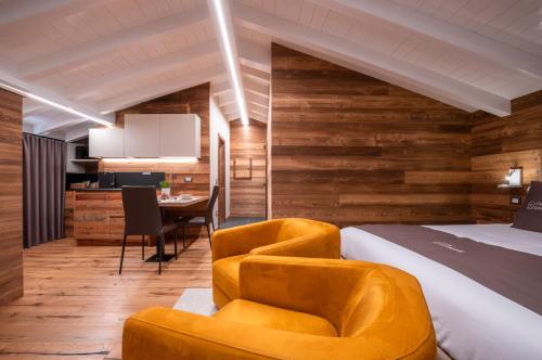 - une chambre avec un lit, deux chaises et une table dans l'établissement Ca' Leonardi - Valle di Ledro, à Ledro