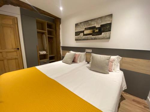 ein Schlafzimmer mit einem großen Bett und einer gelben Decke in der Unterkunft Apartamento Deluxe Casco Viejo in Bilbao