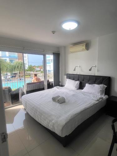 a bedroom with a bed and a view of a pool at Grand Beach Condo A207 in Ban Tha Fat