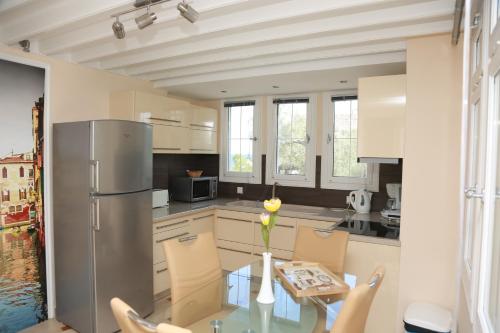 a kitchen with a glass table with chairs and a refrigerator at Sea Sun in Plomarion