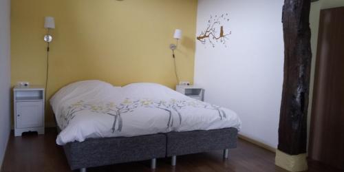 a bedroom with a bed with a white comforter at Boerderij De Aarnink in Heeten