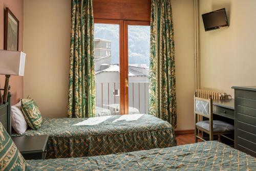 a hotel room with two beds and a window at Hotel Sant Jordi by ALEGRIA in Andorra la Vella