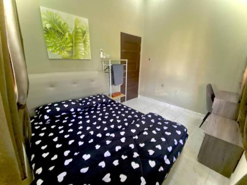 a bedroom with a black and white cover on the floor at Homestay Wakaf Bharu Tumpat in Wakaf Baharu