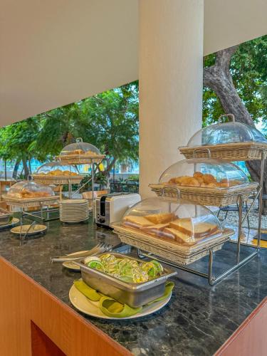 a buffet with several trays of food on a counter at Tamaca Beach Resort in Santa Marta