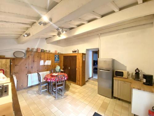 une cuisine avec une table et un réfrigérateur dans l'établissement Maison de campagne à Camps-sur-l'Agly avec vue sur lac, à Camps-sur-lʼAgly