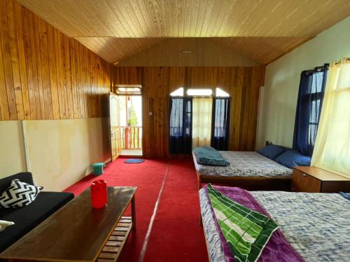 a room with two beds and a red carpet at Kolakham Hillcrest Homestay in Rishop