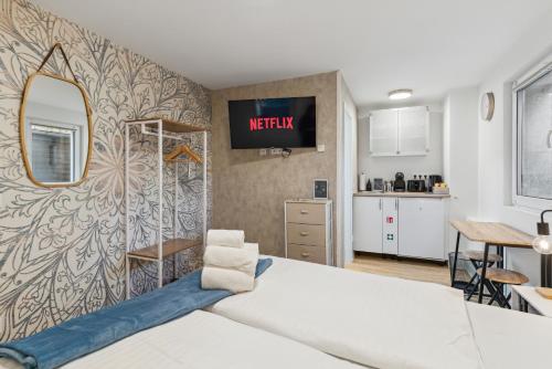 a bedroom with a bed and a mirror and a kitchen at Vorstadtoase - Apartment für 2 Personen mit Smart TV, Parken, eigenen Bad, Netflix - Nähe BER in Eichwalde