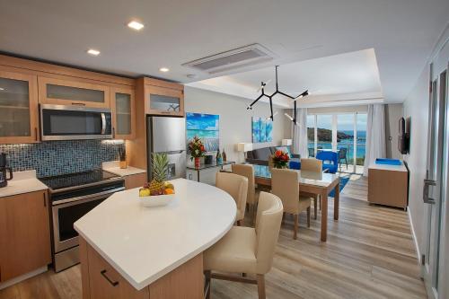 フィリップスブルフにあるOceans at Divi Little Bayの白いテーブルと椅子のあるキッチンとダイニングルーム