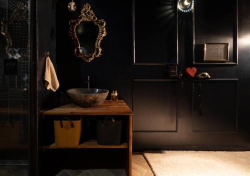 uma casa de banho com uma tigela numa mesa com um espelho em Le Refuge Bleu em Famars