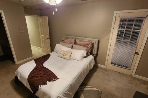1 dormitorio con 1 cama grande con sábanas y almohadas blancas en UrbanEscape 2.0, en Fayetteville