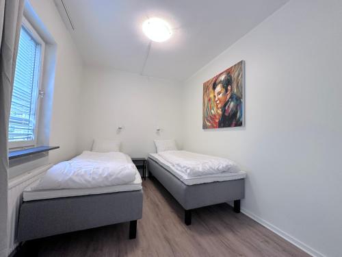 2 letti in una camera con un dipinto sul muro di AD Long Stay Apartments a Stoccolma