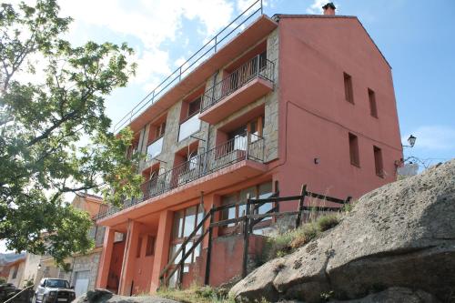 a red building on top of a rock at Hoyo de Los Lobos in Hoyocasero