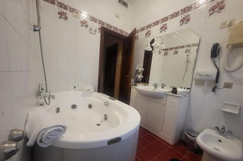基安奇安諾泰爾梅的住宿－GRAND HOTEL LE FONTI，白色的浴室设有浴缸和水槽。