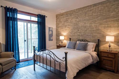 a bedroom with a bed and a brick wall at Tremblant Les Eaux A - Mont-Tremblant in Mont-Tremblant