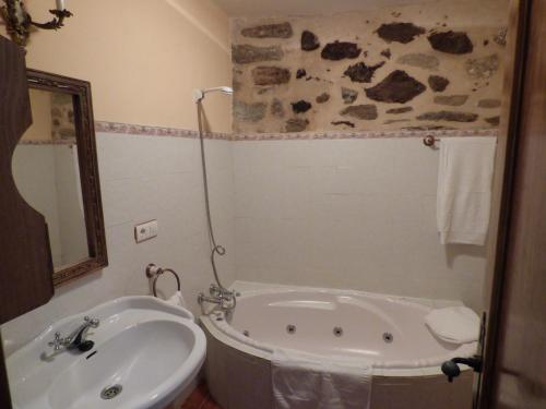a bathroom with a bath tub and a sink at La Posada de Pedrazales in Pedrazales