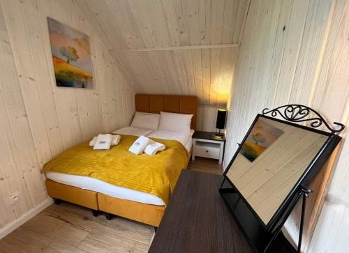a bedroom with a bed with two towels on it at Karkonoskie Zacisze pod Śnieżką in Miłków