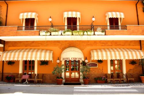 カラマーニコ・テルメにあるHotel Cerconeの目の前にテーブルと椅子が並ぶオレンジ色の建物