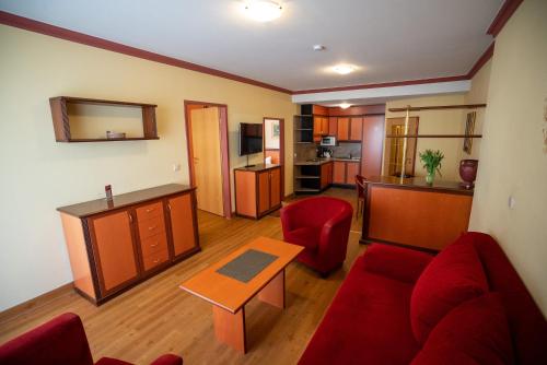 a living room with a red couch and a table at Hotel Esplanade & Aparthotel Rialto in Binz