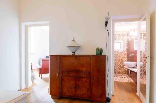une chambre avec une commode en bois et un salon dans l'établissement Casa Cecilia Roma, à Rome
