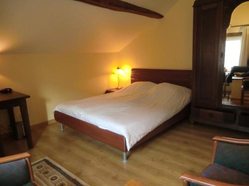 a bedroom with a bed and a table and a chair at Bakhuisje 6p nabij Durbuy in Villers-Sainte-Gertrude