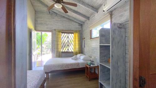 a bedroom with a bed and a ceiling fan at Hotel Raratonga in Santa Teresa Beach