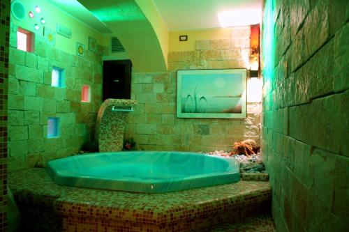 una grande vasca blu in un bagno con un dipinto di Hotel Cercone a Caramanico Terme