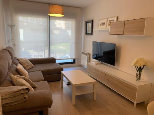 a living room with a couch and a tv at Acogedor apartamento en Baiona in Baiona