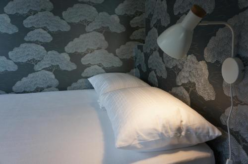 Dormitorio con cama con almohada y lámpara en SUITE Home Ladispoli, en Ladispoli