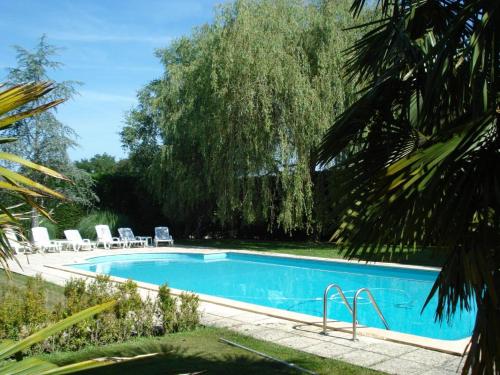 a swimming pool in a yard with chairs and a tree at La tour du guet in Arouille