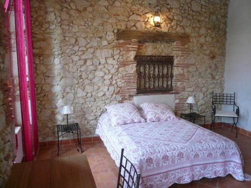 a bedroom with a bed in a stone wall at La tour du guet in Arouille