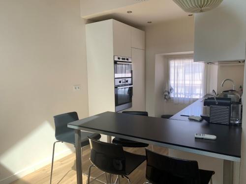 une cuisine avec une table et des chaises noires dans l'établissement Large Studio Flat 4 pax THU9, à Cannes