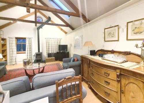 a living room with a large wooden dresser at Edinburgh 2-Bedroom Cottage with Parking - Ground Floor in Edinburgh