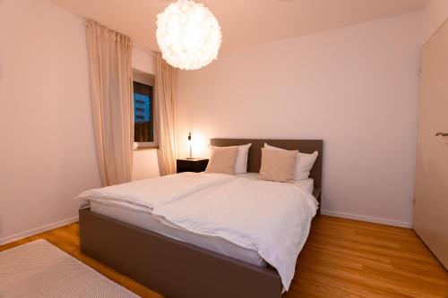 a bedroom with a large bed with a chandelier at Wohnung mit Tiefgarage u. Balkon in Paderborn