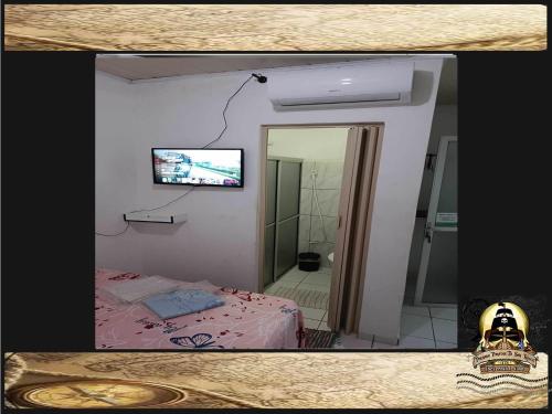 a room with a bed and a television on a wall at Pousada Piratas Di San Rocco in Maceió