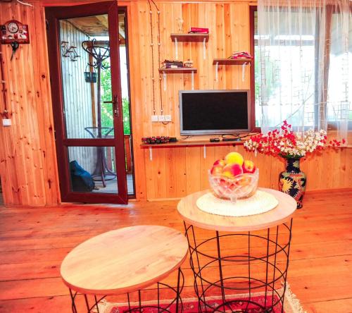 Habitación con mesa, 2 taburetes y TV. en Cottage Racha Rhymes en Ambrolauri