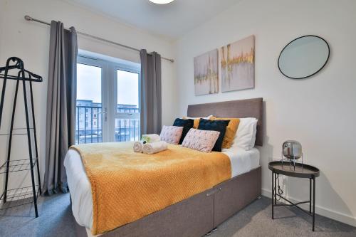 - une chambre avec un lit et une grande fenêtre dans l'établissement StayRight 2 Bedroom Flat with Private Parking on Waterfront, à Barry