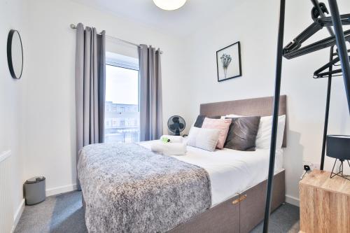 a bedroom with a bed and a large window at StayRight 2 Bedroom Flat with Private Parking on Waterfront in Barry