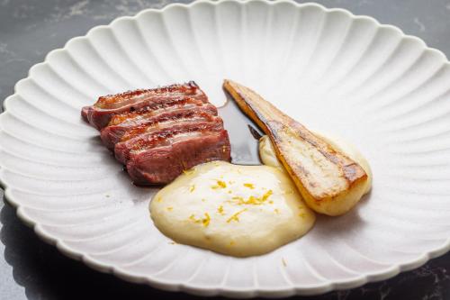 a paper plate with meat and potatoes on a table at Nunne Boutique Hotel in Tallinn