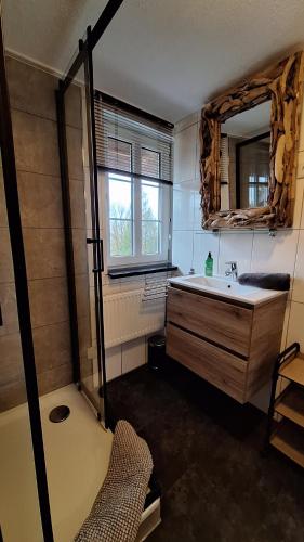 a bathroom with a tub and a sink and a mirror at Haus Blick am Edersee in Waldeck