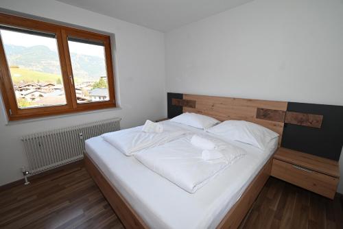 uma cama branca num quarto com uma janela em Apartement Karen TOP 35 - by Four Seasons Apartments em Kaprun