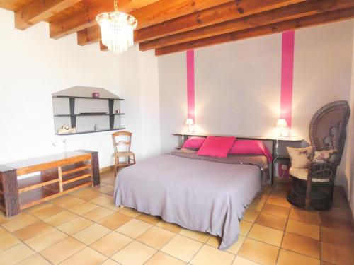 um quarto com uma cama com almofadas cor-de-rosa em Le grand bidot em Louer