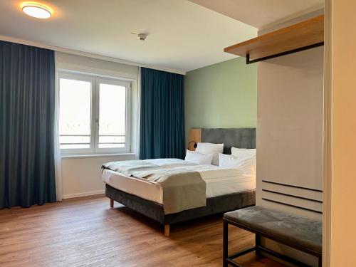 een slaapkamer met een bed en een groot raam bij AMH - Wohnen auf Zeit in München