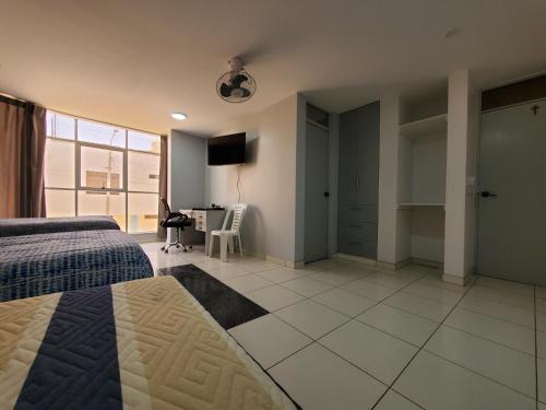 1 dormitorio con 1 cama y 1 habitación con escritorio en Hotel Real San Pedro, en El Puente