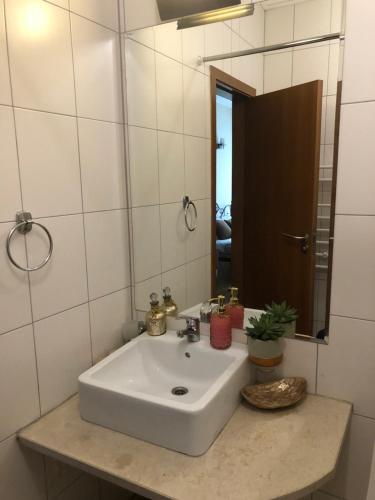 lavabo blanco en el baño con espejo en GONDOLAs LODGE, en Bansko